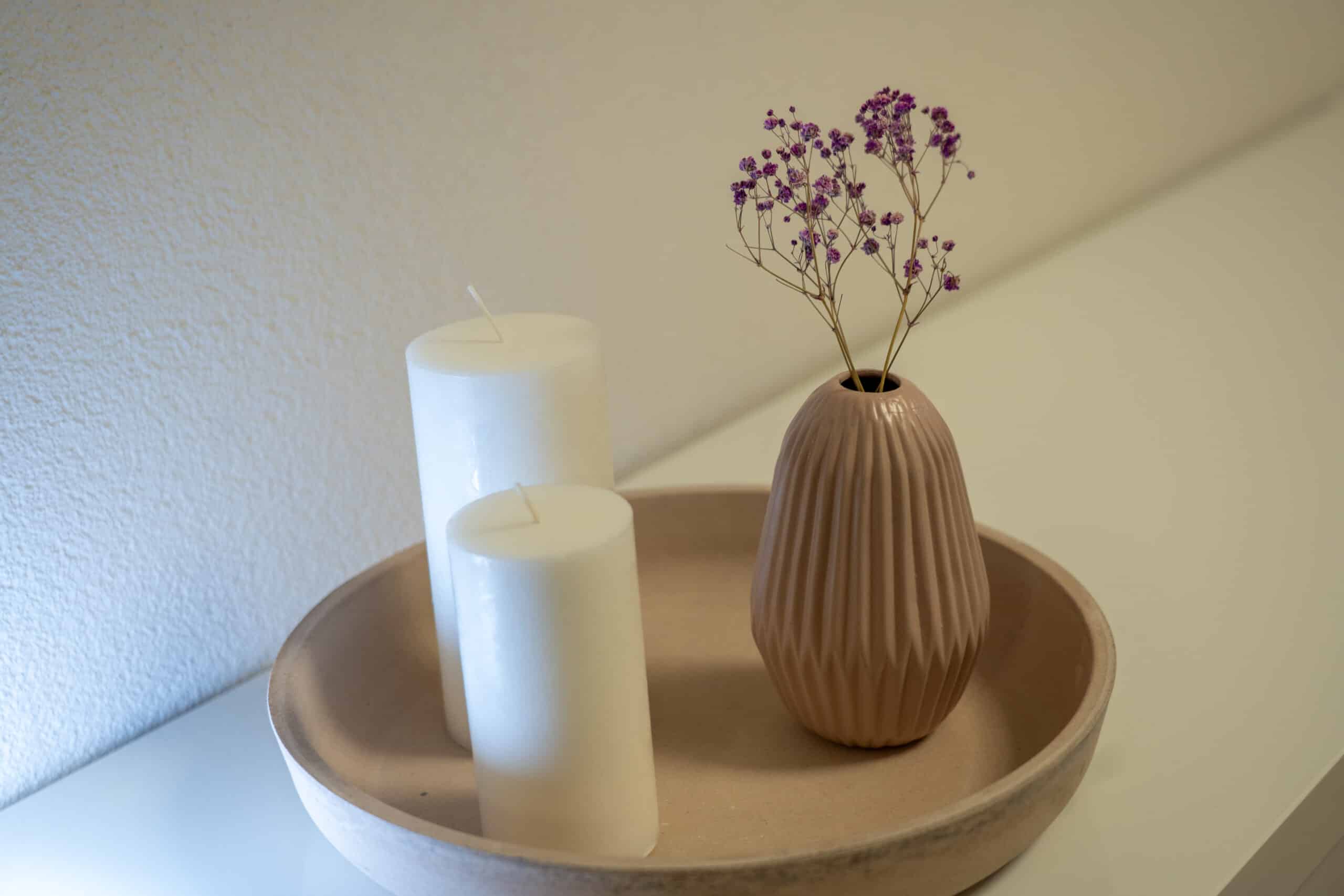 Schönes Ambiente im Kosmetikstudio: Kerzen, Vase und Blumen.