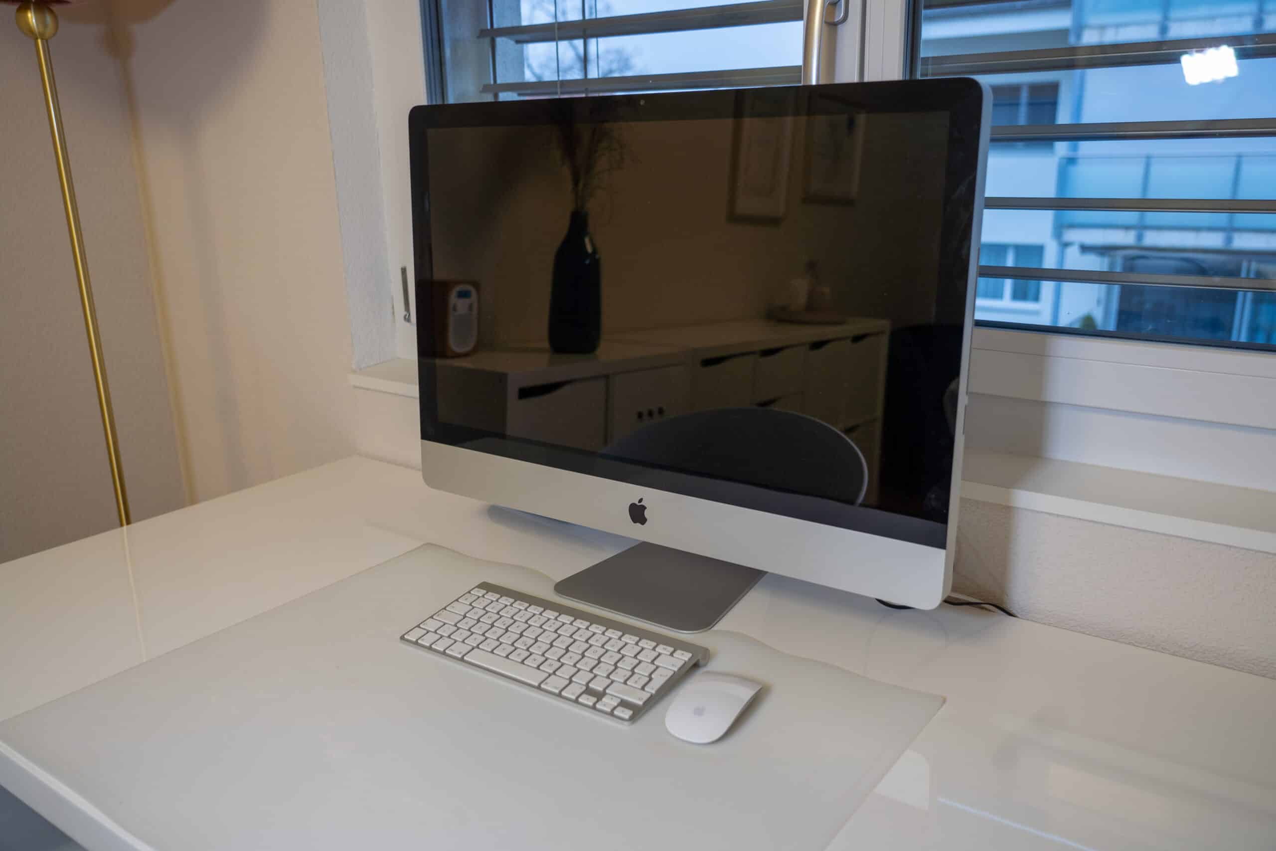 Moderner Schreibtisch mit iMac und Zubehör, ideal für die Arbeit.